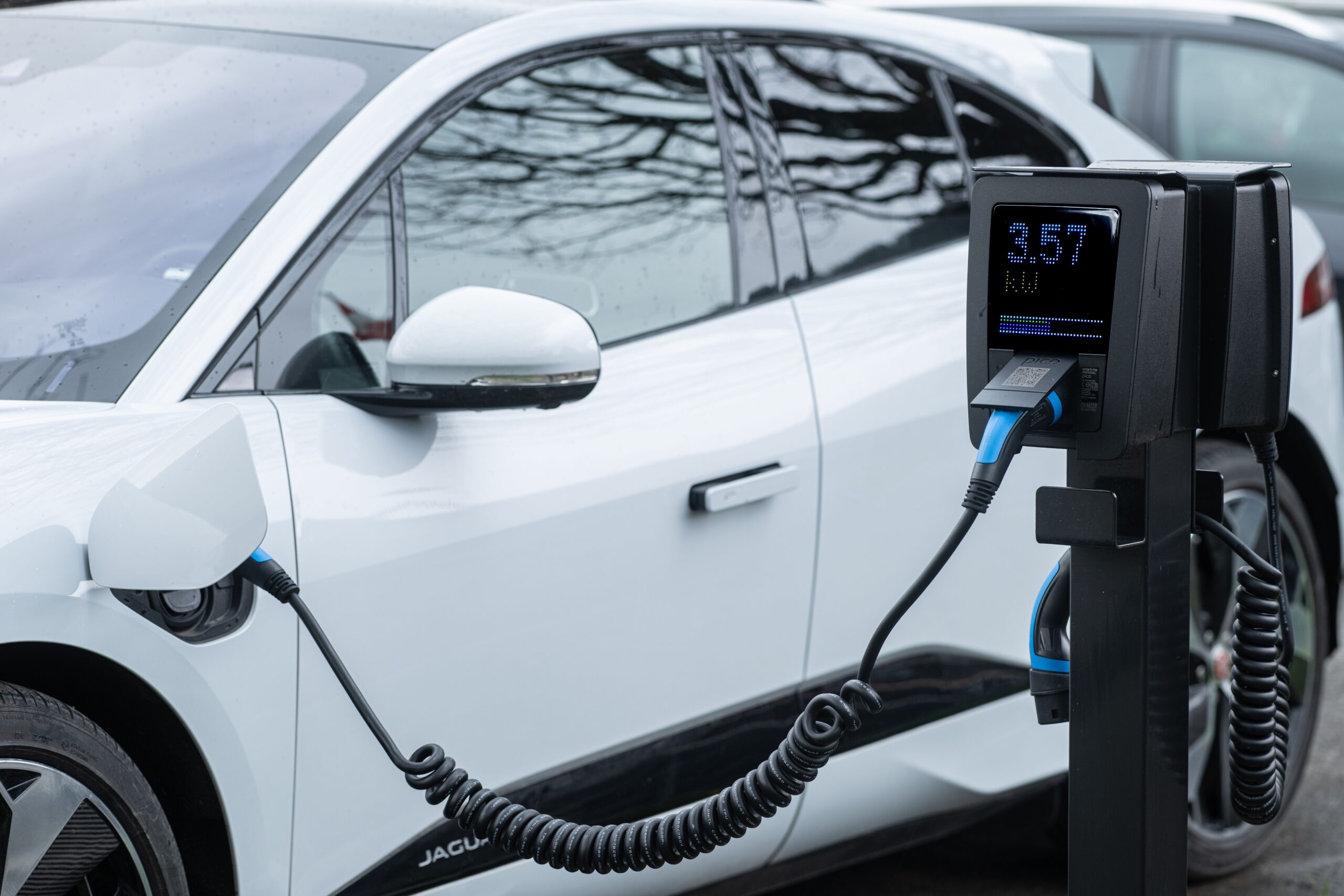 Nahaufnahme eines Elektrofahrzeugs beim Laden an einer Ladesäule